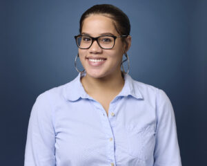 A headshot with a blue background.